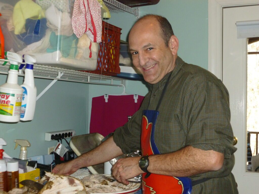 My wonderful husband cutting the turkey, confined to the laundry room because the turkey is so messy, and still smiling away!