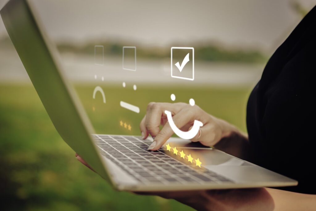 Businesswoman pressing face emoticon on the keyboard laptop. Customer service evaluation concept.