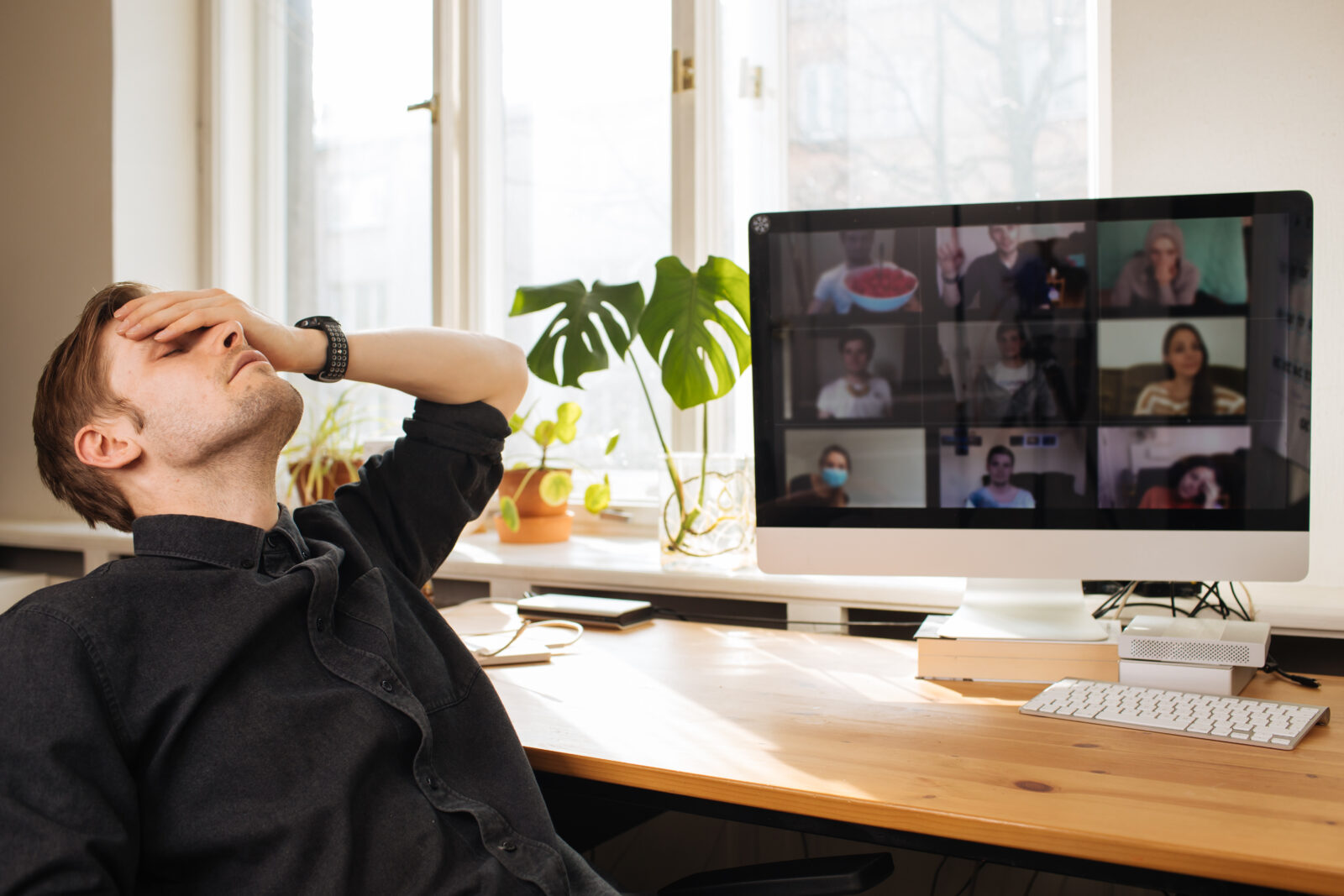 Man Fatigue during home video conference meeting call. Post-work exhaustion from constant face-to-face digital interactions. Working remotely Stay connected during pandemic to combat loneliness