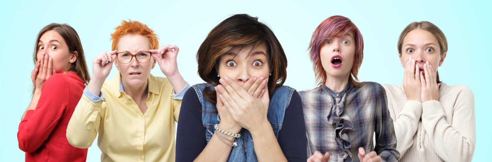Horizontal portrait of several female closes hands over mouth in shock by what they heard.