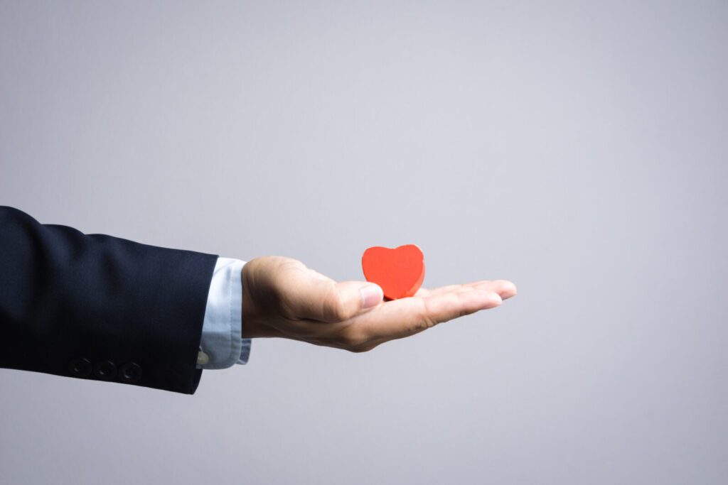 Business man hand with wooden red heart object